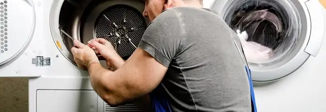 Dryer repair technician fixing a clothes dryer drum in Tulsa, OK