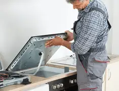 Appliance repair technician installing a built-in cooktop in Tulsa, OK