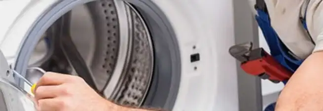 Appliance technician repairing a clothes dryer drum and internal parts in Tulsa, OK