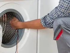 Dryer repair technician diagnosing and servicing a clothes dryer in Tulsa, OK