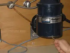 Garbage disposal repair technician tightening the mounting ring under a sink in Tulsa, OK