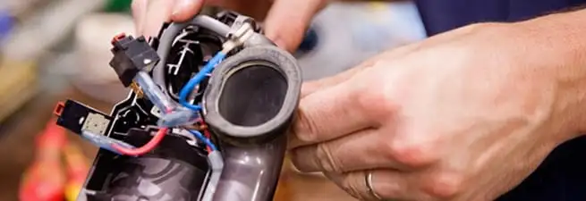 Vacuum repair technician reconnecting wiring and components in Tulsa, OK