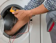 Washing machine repair technician testing a front-load washer with diagnostic tools in Tulsa, OK