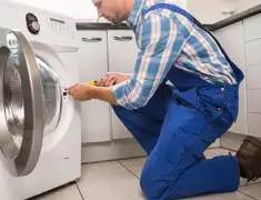 Washing machine repair technician servicing a front-load washer in Tulsa, OK