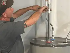 Water heater repair technician tightening supply line connections in Tulsa, OK